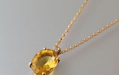 Pendant and its chain in 750 thousandths yellow gold, it is decorated in its center with an oval-shaped yellow fluorite calibrating approximately 2.75 carats, surmounted by a modern cut diamond.