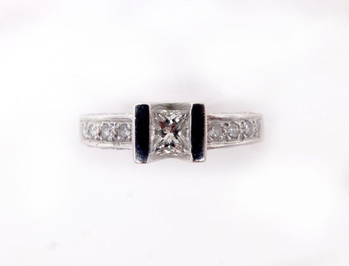 RING in 18K white gold holding twenty-five brilliant-cut diamonds, of which the center diamond is approximately 0.30 carat princess cut. Gross weight: 3.9 gr. TDD: 51. Estimated diamond weight: 0.45 carat. A white gold and diamond ring.