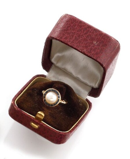 RING in 18K yellow gold, holding in its center a pearl (untested) in a surround of sapphires. French work. Original case. TDD : 50. Pearl diameter : 7 mm. Gross weight : 2.55 gr. A yellow gold, cultured pearls and sapphire ring.