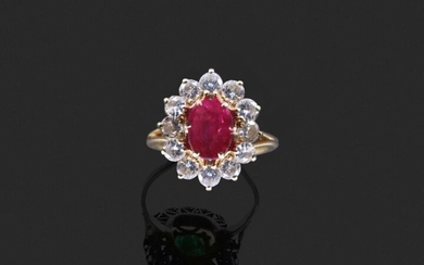 RING in 750 thousandths yellow gold decorated in the centre with an oval ruby in a setting of twelve round brilliant diamonds. Finger size: 52.5. Presumed weight of the ruby: about 1 to 1.30 ct. Gross weight: 5.7 g. (ruby rubies). Yellow gold ring...