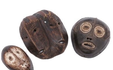 Three masks of carved patinated wood. Lega style. H. 19–29 cm. (3)