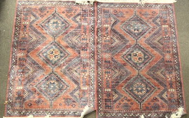 Two contemporary viscose rugs. With blue and beige geometric patterns on a red ground, with tassels.