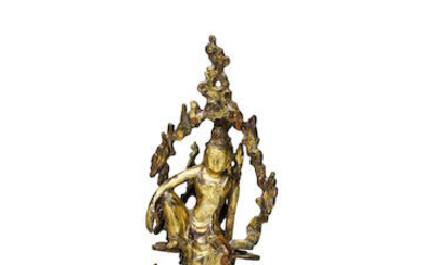 A GILT-BRONZE FIGURE OF GUANYIN IN A GROTTO