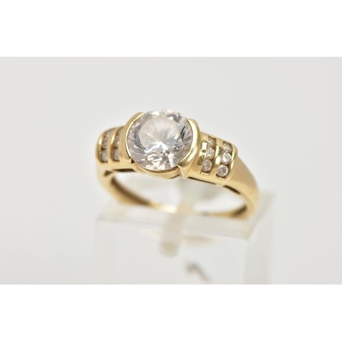 A 15CT GOLD CUBIC ZIRCONIA DRESS RING, designed with a centr...