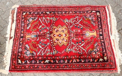 A 20TH CENTURY PERSIAN RUG, bright red ground with