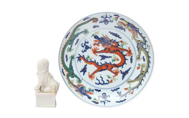 A CHINESE WUCAI 'DRAGONS' DISH AND A DEHUA FIGURE 十八至二十世紀 五彩飛龍趕珠紋盤及德化白釉佛獅 《大明嘉靖年製》款
