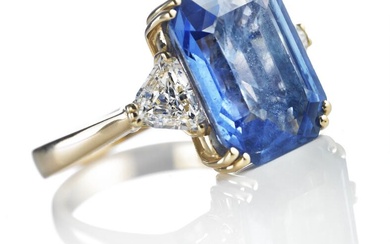 A Ceylon sapphire and diamond ring set with an emerald-cut natural Ceylon sapphire weighing app. 9.85 ct. flanked by two shield-cut diamonds weighing a total of app. 0.90 ct., mounted in 18k gold. Colour: Top Cape (K). Clarity: VS. Size 54.