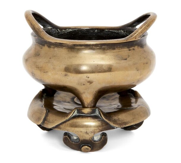A Chinese polished bronze two-handled tripod censer...