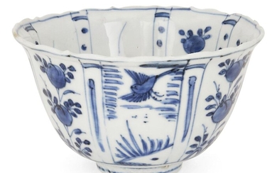 A Chinese porcelain Kraak blue and white 'flying birds' bowl, 17th century, the exterior painted with rectangular panels enclosing birds in flight, bamboo and fruiting peaches, the interior decorated with a lone bird perched atop a rocky outcrop...