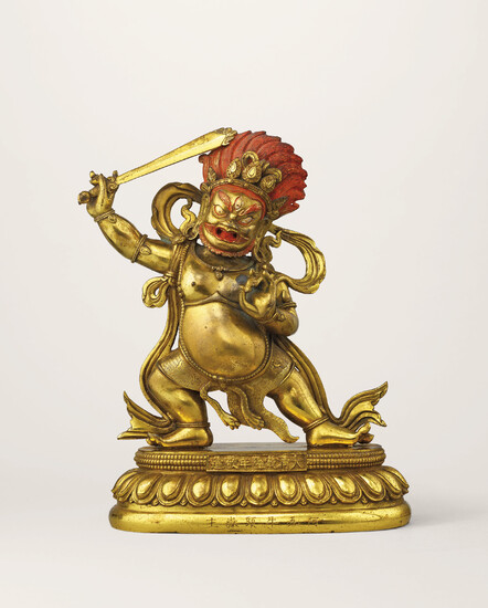 A GILT-BRONZE FIGURE OF DHARMAPALA AND A STAND, QIANLONG CAST SEVEN-CHARACTER MARK AND OF THE PERIOD (1736-1795)