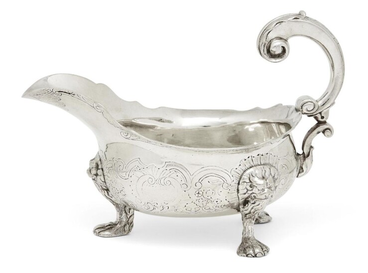 A George II silver sauce boat, London, c.1748, maker's mark rubbed, designed with three paw feet to lion mask shoulders, the floral scroll chased body to double scroll handle and shaped rim, 18.5cm long 13.6cm high (both inc. handle), approx...