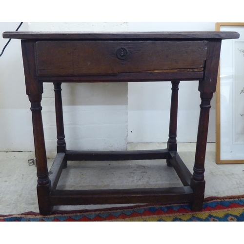 A George III oak single drawer side table, raised on turned ...