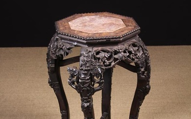 A Late 19th Century Chinese Carved Hardwood Jardiniere Stand (A/F).The octagonal top with pink marbl