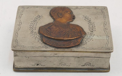 A Thai white metal rectangular box, 20th century, the hinged cover set with a copper plaque, depicting a king of Thailand, 13.5cm wide
