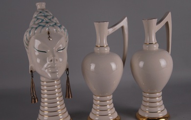 A bottle in the shape of a woman's head and two pourers