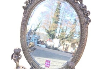 A brass dressing table mirror, the oval frame with...