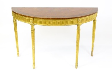 A demi lune console table with a marquetry inlaid top above a fluted frieze and moulded floral