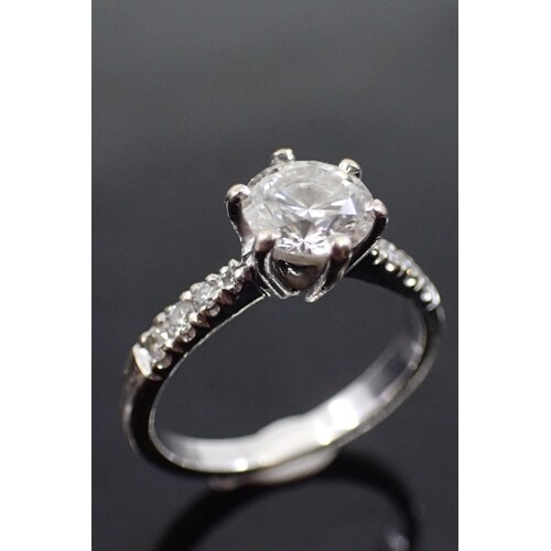 A diamond single stone ring set with diamond shoulders in 18...
