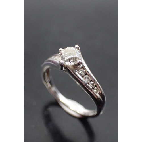 A diamond single stone ring set with diamond shoulders, with...
