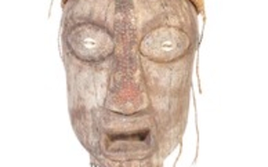A large 20th Century tribal African figure with horn set to head with inset shells to eyes. Glass bead necklaces with cloth skirt raised on pedestal base. Measures approx; 80cm tall.
