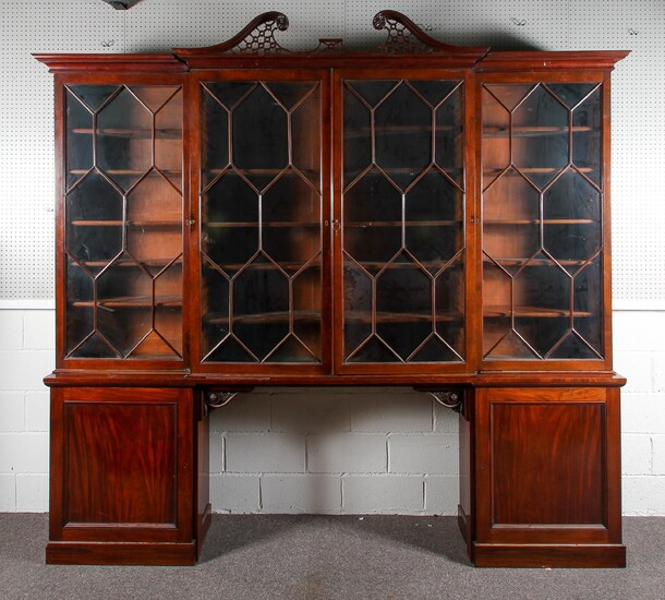 A large early 19th century mahogany four section bookcase, with pierced frettwork broken pediment