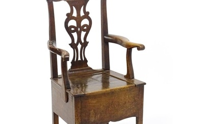 A late Georgian oak commode chair with a Chippendale style b...
