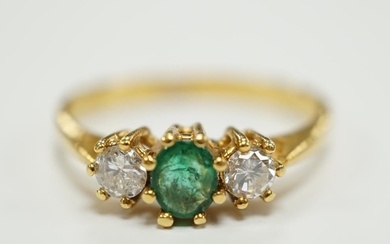 A modern 18ct gold, emerald and diamond set three stone ring...