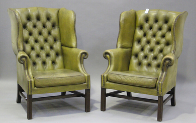 A pair of 20th century George III style wing back armchairs, upholstered in buttoned green leather