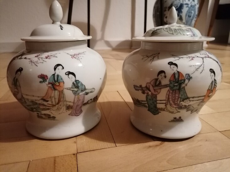 A pair of Chinese enamelled porcelain lidded vases painted with scenary and poetry. Sealmark of Tongzhi. H. 20 cm. (2)