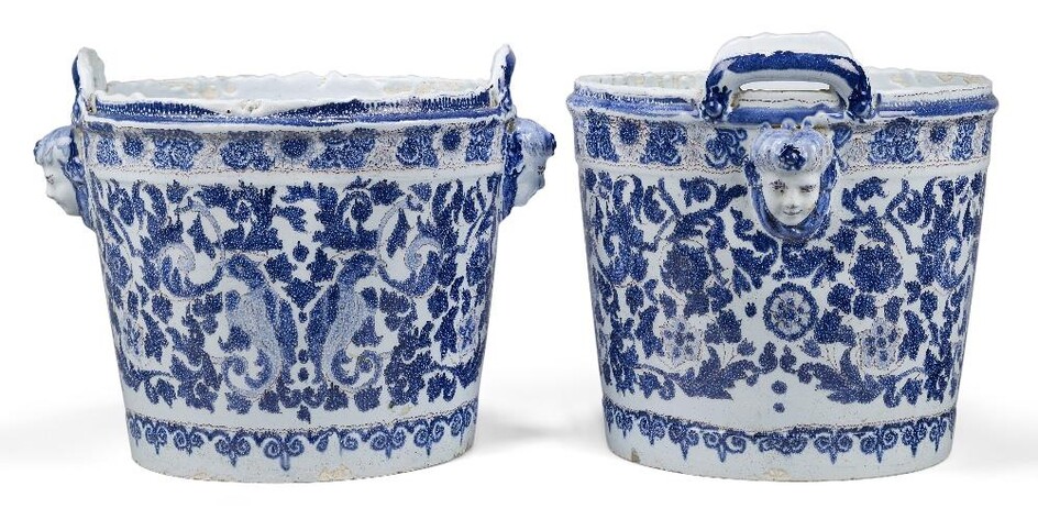 A pair of Continental faÃ¯ence two-handled jardiniÃ¨res, probably c.1900, blue N marks, of bucket-shaped form, each with masks below lug handles, painted in dark-blue and manganese with fantastic birds gripping foliate scrolls in their beaks...