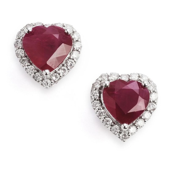 A pair of ruby and diamond ear studs each set with a heartshaped ruby weighing a total of app. 2.95 ct. encirled by numerous brilliant-cut diamonds weighing a total of app. 0.25 ct., mounted in 18k white gold. Colour: H. Clarity: SI-P. W. 7 mm. (2)