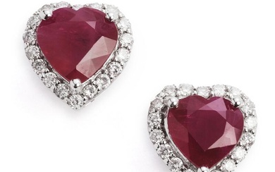 A pair of ruby and diamond ear studs each set with a heartshaped ruby weighing a total of app. 2.95 ct. encirled by numerous brilliant-cut diamonds weighing a total of app. 0.25 ct., mounted in 18k white gold. Colour: H. Clarity: SI-P. W. 7 mm. (2)