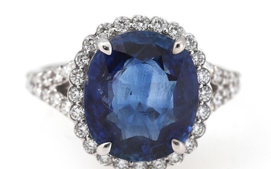 A sapphire and diamond ring set with an oval-cut sapphire weighing app....