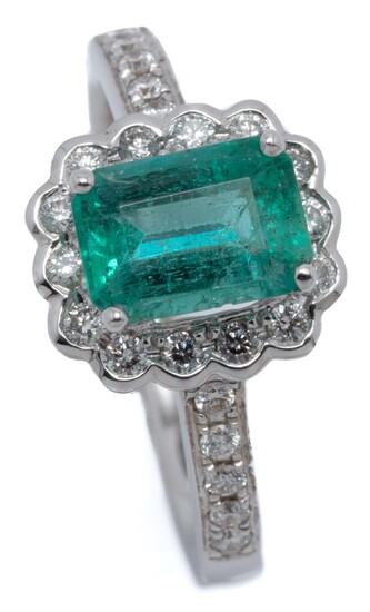 AN 18CT WHITE GOLD EMERALD AND DIAMOND RING; centring an emerald cut emerald of approx. 1.15ct to surround and shoulders set with a...