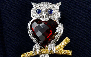 An 18ct gold diamond and garnet owl brooch, with sapphire eyes, perched on a 'yellow' diamond branch, by E. Wolfe & Co.