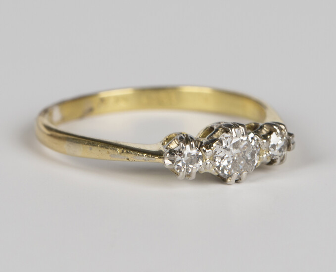 An 18ct platinum and diamond ring, claw set with the principal circular cut diamond between two smal