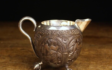 An Eastern Silver Metal Mounted Coconut Shell Jug. The sides intricately carved with figures in arch