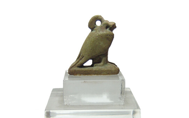 An Egyptian faience amulet in the form of a falcon