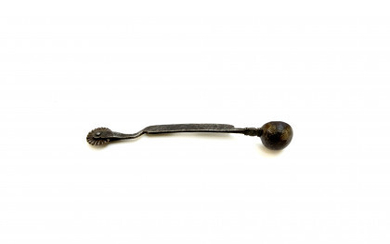 An iron pastry jigger with spoon