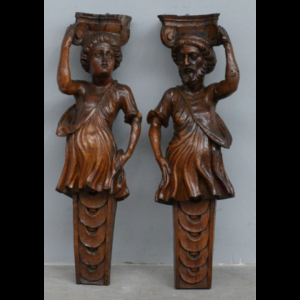 Coppia di antiche lesene in legno scolpito a figure di cariatidi che reggono capitelli (h. cm 80) (mancanze)