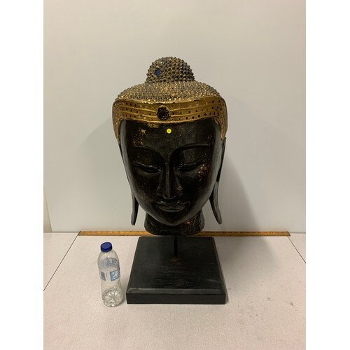 Extremely large carved wooden Thai Buddha head on wooden sta...