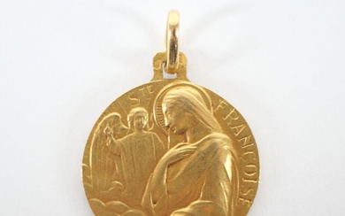 Médaille religieuse circulaire en or jaune 18K figurant Sainte Françoise. Chiffrée et datée au revers....