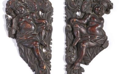 Pair of 17th Century walnut appliques, designed as spandrels, carved as cherubs among scrolling