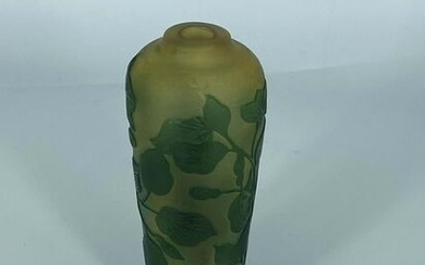 Un petit vase à fleurs vertes sur fond jaune