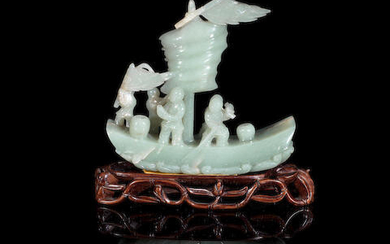 A pale green jade carving of a sailing boat with crew