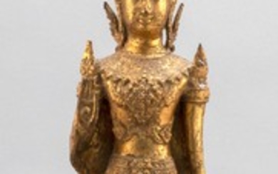 TIBETAN GILT-BRONZE FIGURE OF BUDDHA Standing on a conforming tiered base, dressed in ceremonial headdress and robes and with the ri...