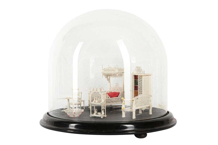 A 19TH CENTURY CARVED BONE SET OF MINIATURE FURNITURE WITHIN A GLASS DOME