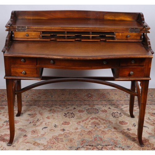 A CHERRYWOOD DESK of rectangular bowed outline the hinged to...