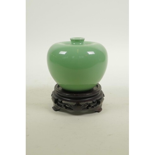 A Chinese apple green glazed porcelain vase, on a carved har...