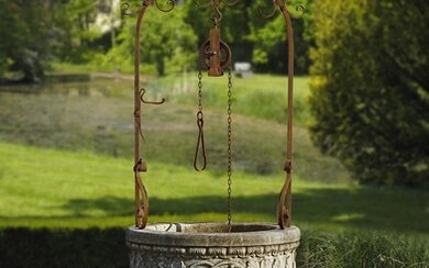 A Continental sculpted limestone and wrought iron mounted well head